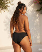 Modelo mediterránea talla L de espaldas con el bikini menstrual Apparelle — diseño seamless con cobertura posterior completa, fit confortable en cuerpos reales.