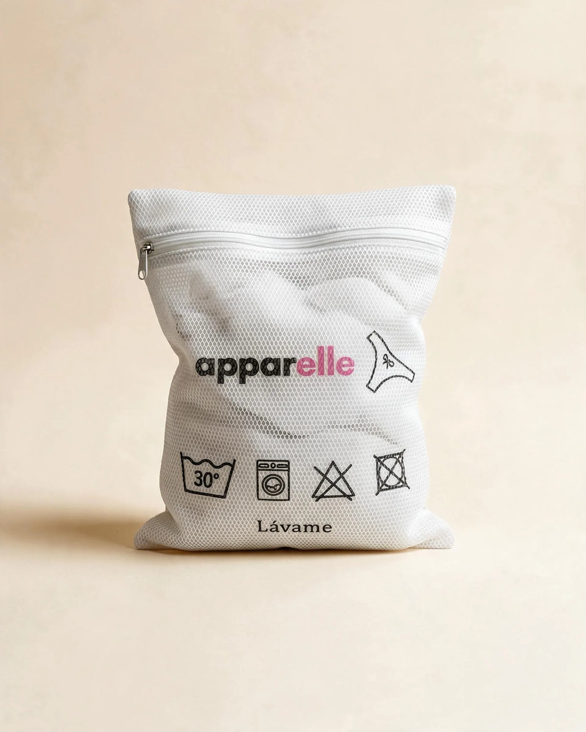 Bolsa de lavado de malla blanca Apparelle para braguitas menstruales, con instrucciones de lavado impresas, sobre fondo crema