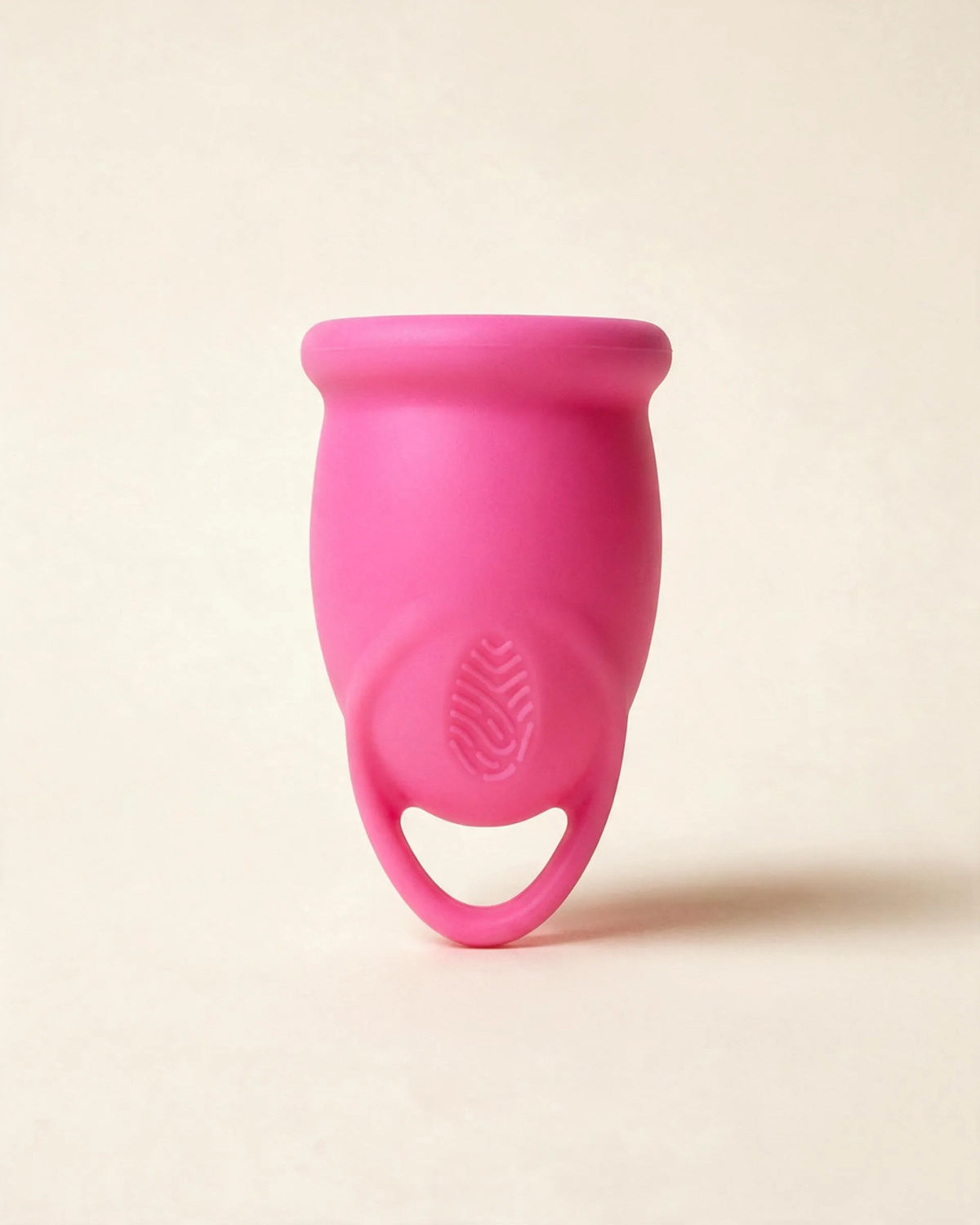Copa menstrual Apparelle de silicona en rosa, sobre fondo crema