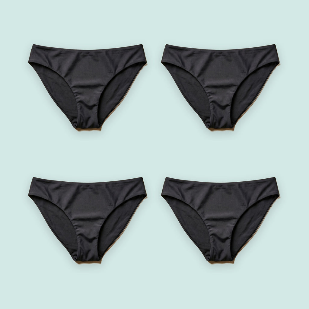 Pack de cuatro bikinis menstruales Apparelle en negro sobre fondo verde agua