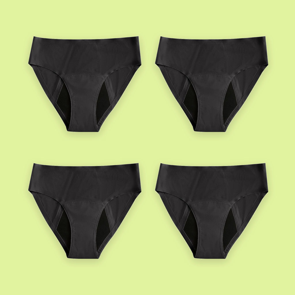 Pack de cuatro braguitas menstruales Apparelle Signature en negro, colocadas en cuadrícula sobre fondo lima