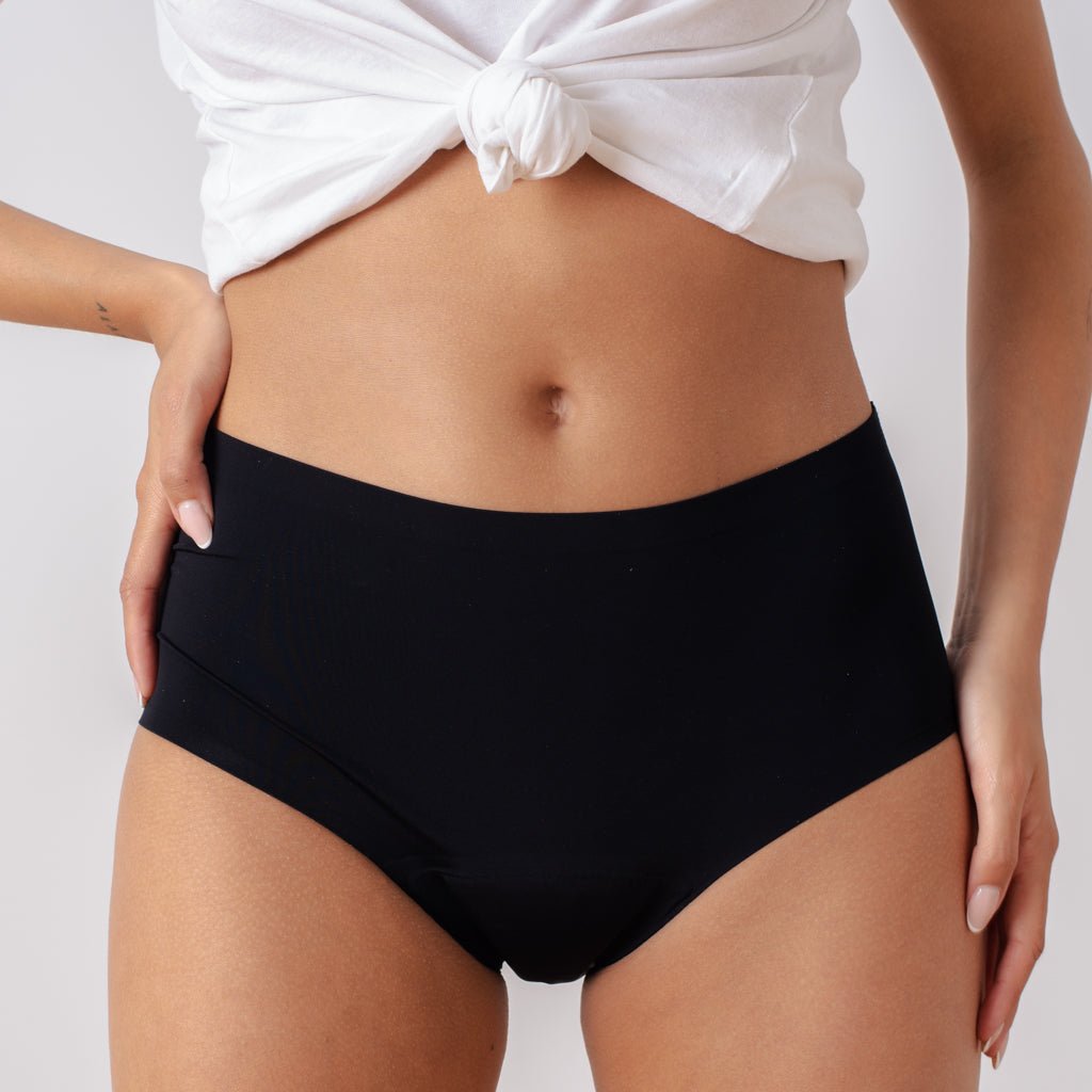 Braga menstrual de tiro alto Apparelle negra - vista frontal en modelo mostrando cintura alta y cobertura completa